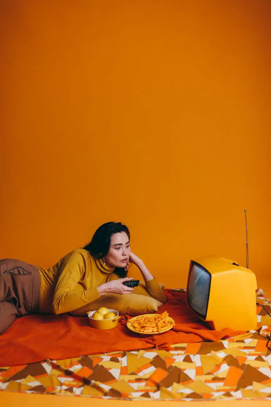 woman in yellow long sleeve shirt watching tv