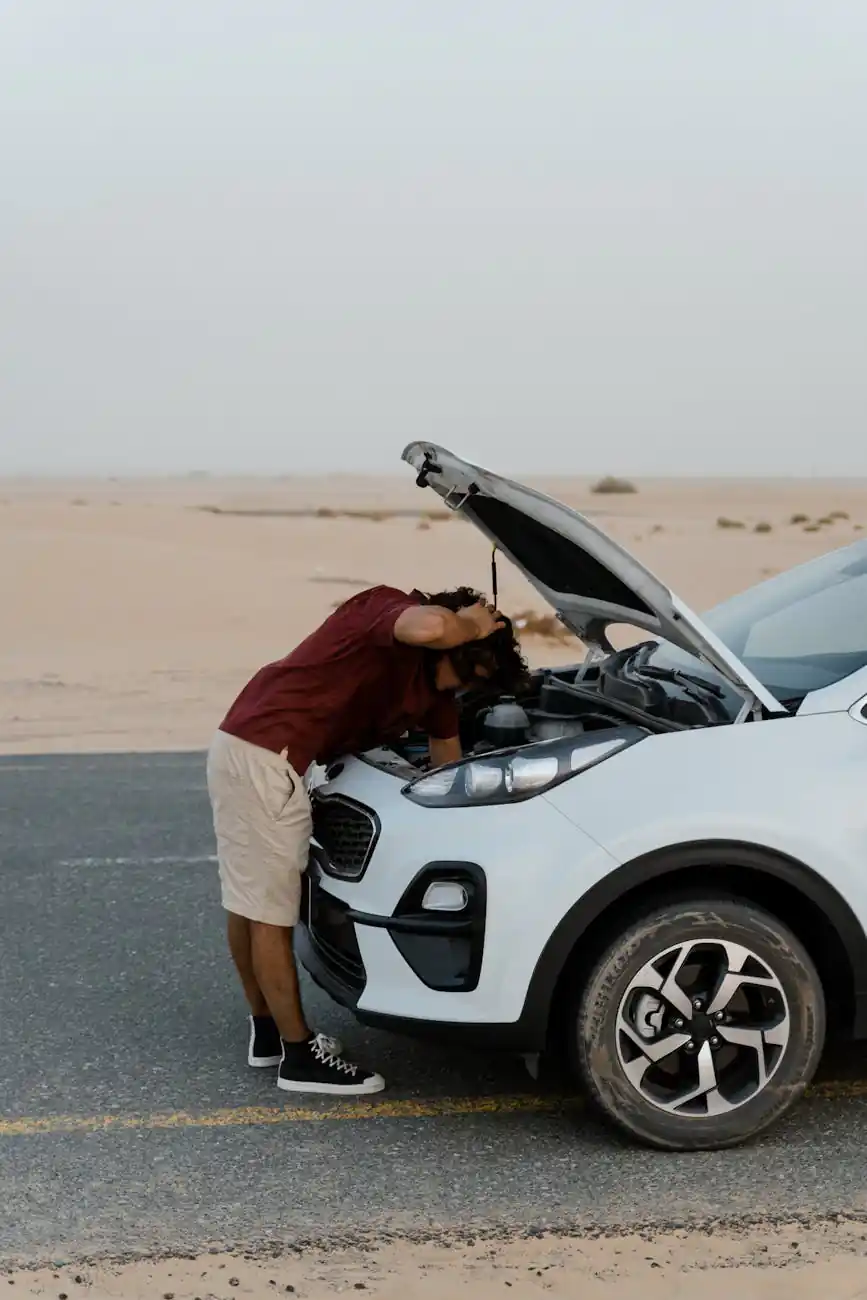 a man checking his broken car