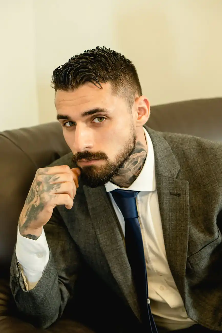 portrait of a man with tattoos wearing a gray suit