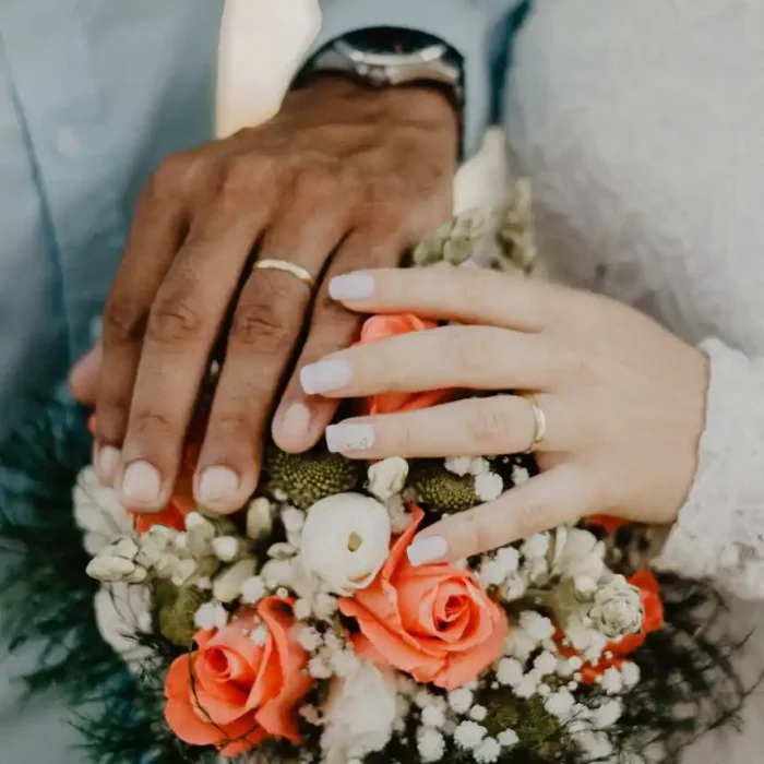 man and woman s hands on top of ball bouquet
