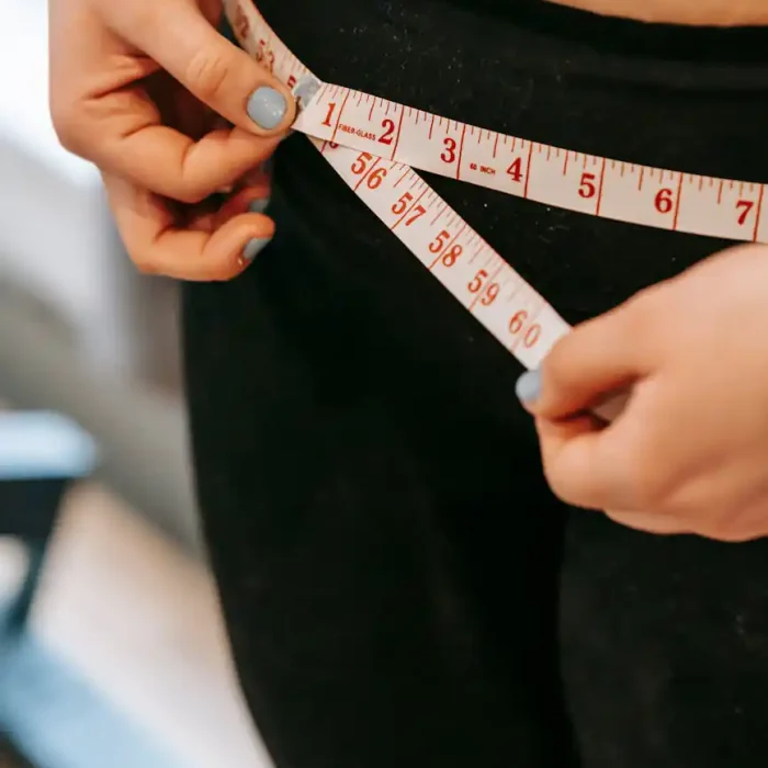 woman measuring her hips