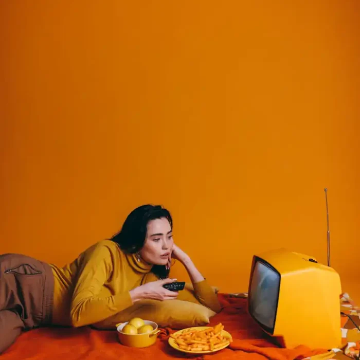 woman in yellow long sleeve shirt watching tv