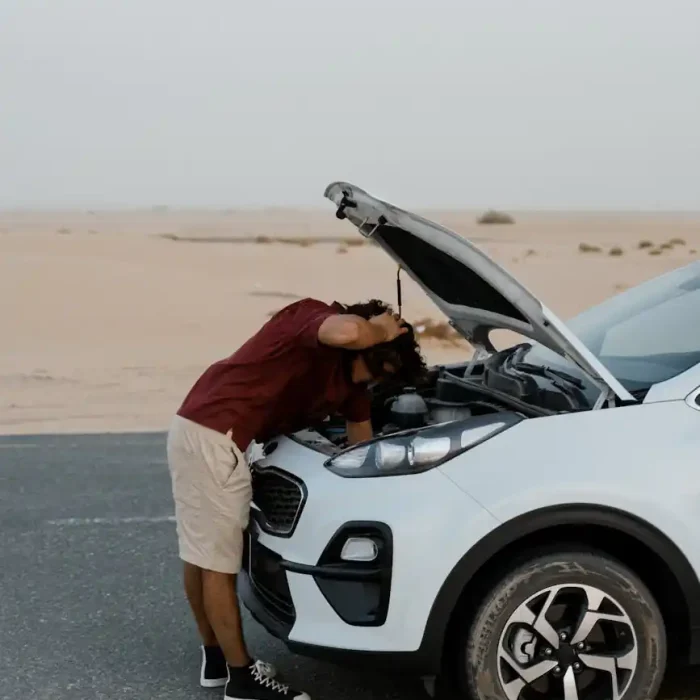 a man checking his broken car